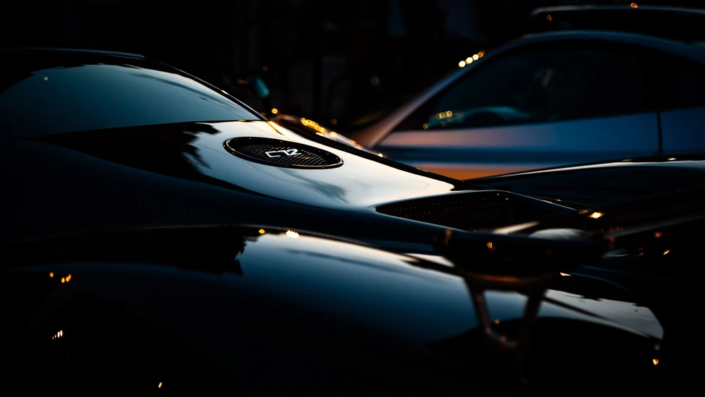 Sleek black supercar reflecting Melbourne skyline